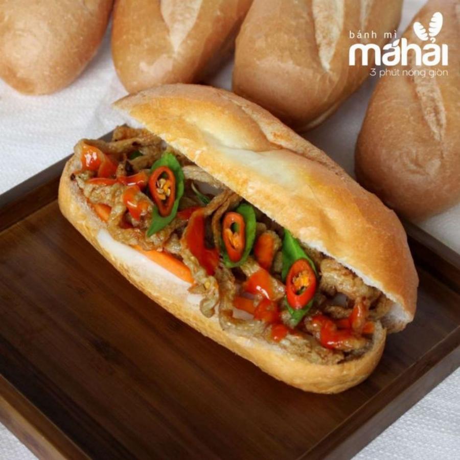 Bánh mì Hội An Quận 7 nhân đầy đủ với pate, chả lụa, thịt nướng và rau thơm tươi xanh