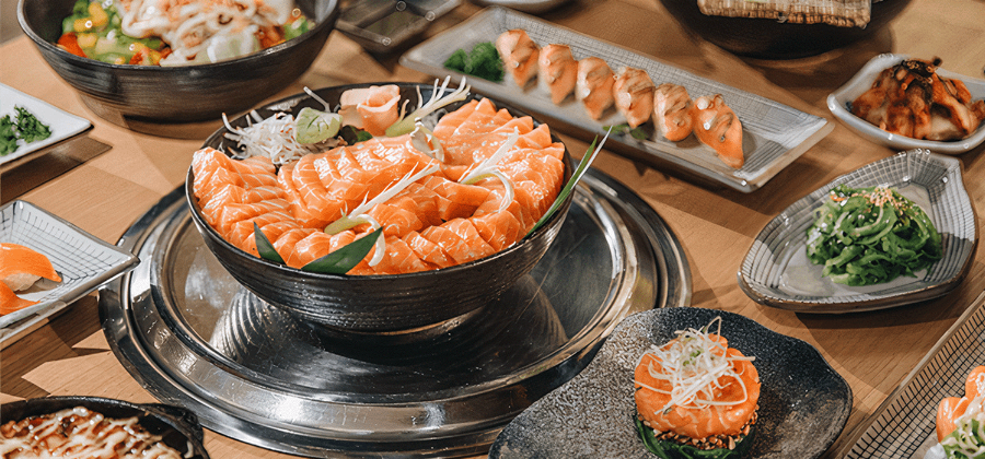 Hình ảnh thực khách đang xem thực đơn và lựa chọn món tại một nhà hàng sushi ở Vạn Hạnh Mall. 