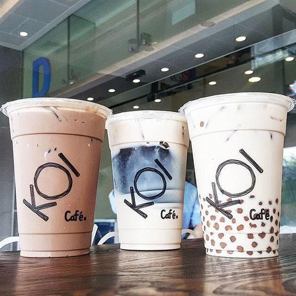 Một ly trà sữa trân châu hấp dẫn và một phần bánh ngọt đẹp mắt đặt trên bàn tại một quán cà phê trong Lotte Mart Quận 11